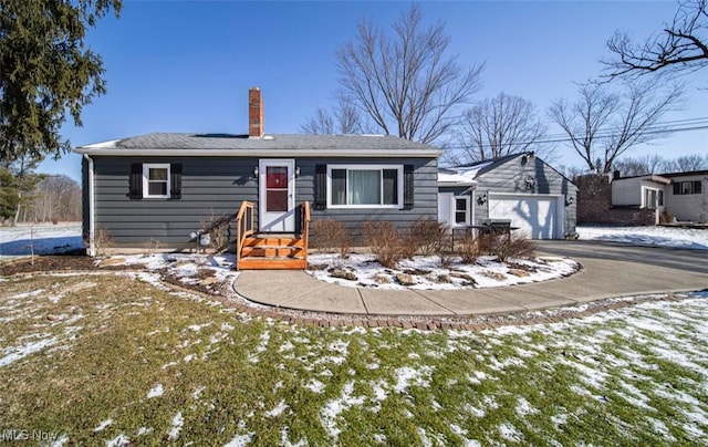 view of front of home with a garage, a chimney, and aphalt driveway