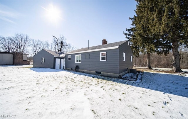 snow covered property with a chimney