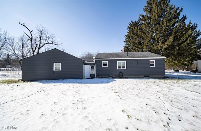 view of snow covered back of property