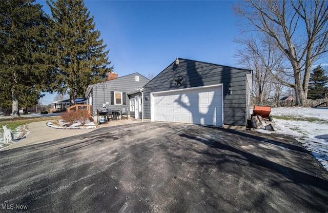 view of front facade featuring a garage and aphalt driveway