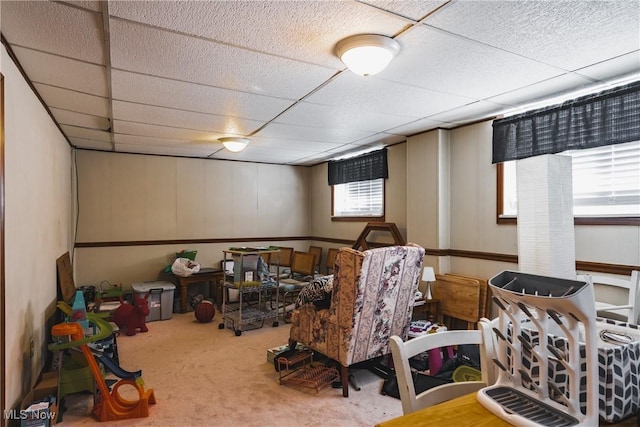 basement with carpet flooring and a paneled ceiling