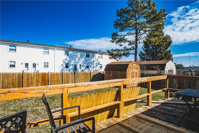 wooden deck with a storage shed, an outdoor structure, and fence