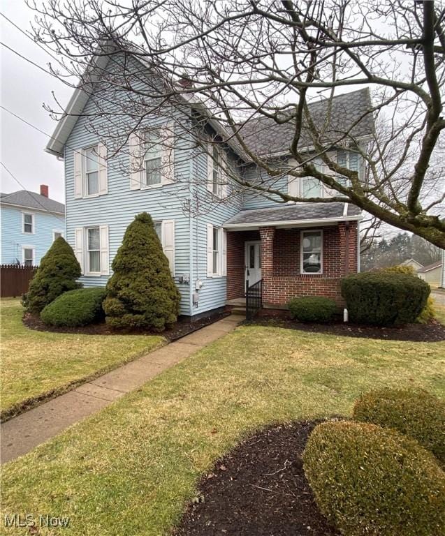 view of front of property with brick siding and a front yard