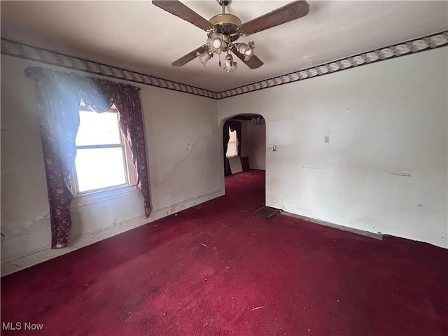 unfurnished room featuring arched walkways, ceiling fan, and visible vents