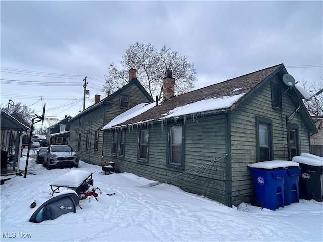 view of snowy exterior with a chimney