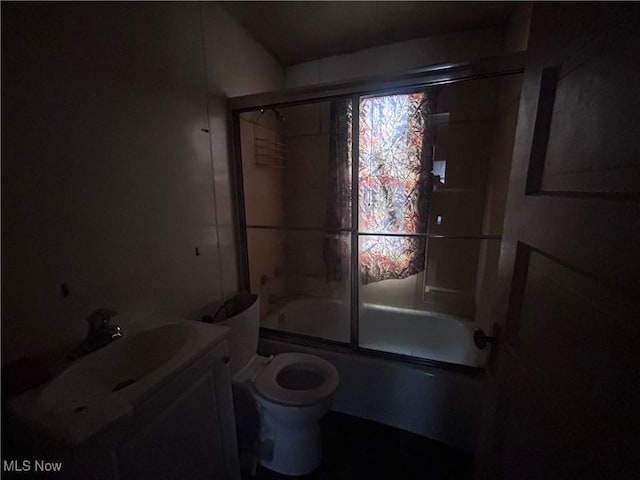 bathroom with toilet, bath / shower combo with glass door, and vanity