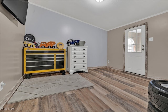 foyer featuring crown molding, baseboards, and wood finished floors