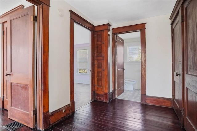 hallway featuring dark wood-style floors and baseboards