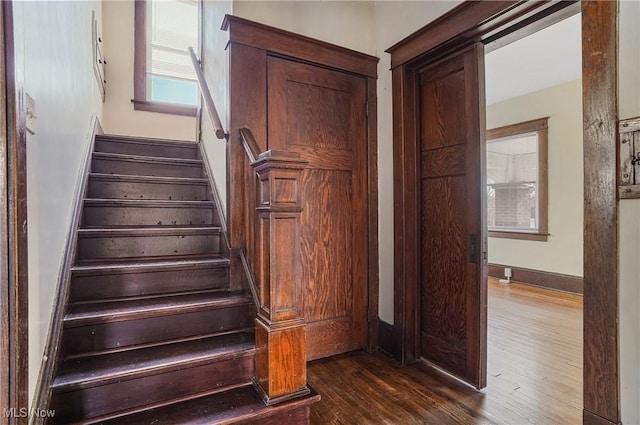 stairs with wood finished floors and baseboards