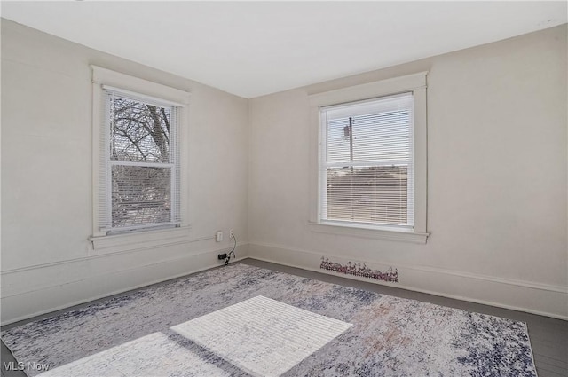 spare room featuring baseboards and a healthy amount of sunlight