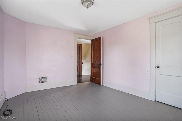 unfurnished room with hardwood / wood-style flooring and baseboards