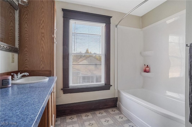 bathroom featuring  shower combination, vanity, baseboards, and tile patterned floors