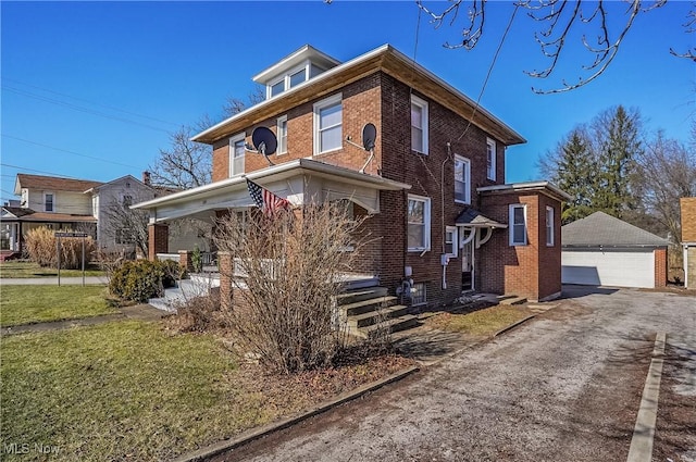 american foursquare style home with a garage, brick siding, a front lawn, and an outdoor structure