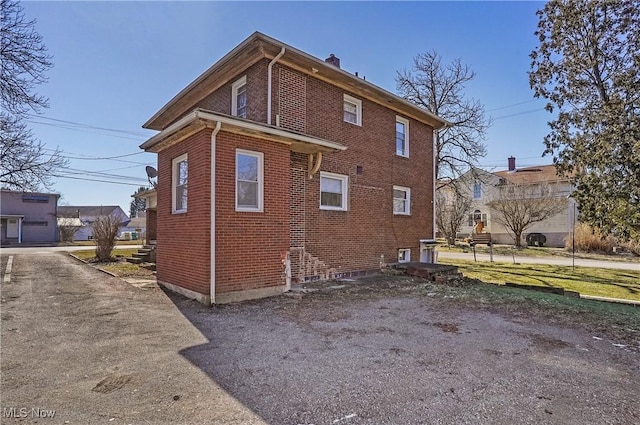 view of home's exterior featuring brick siding and a chimney