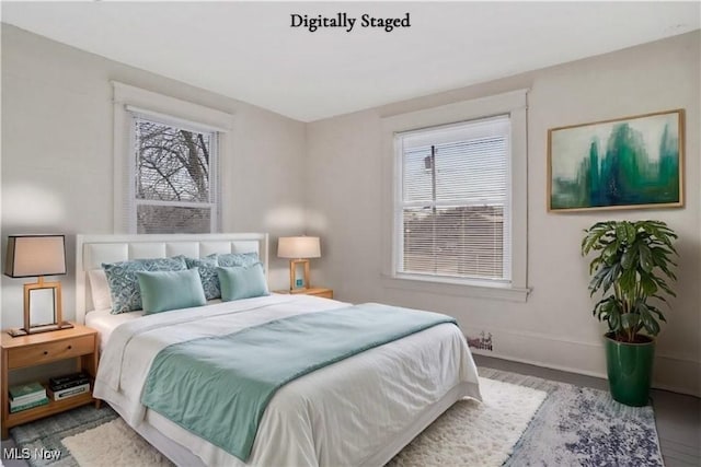 bedroom with baseboards and wood finished floors