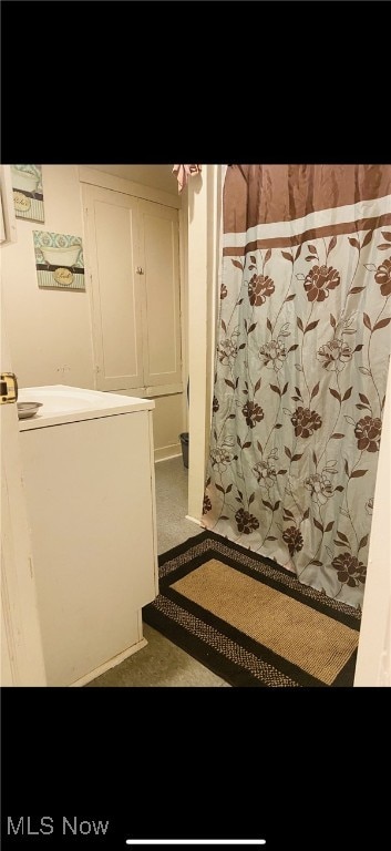 full bath featuring washer / clothes dryer and a shower with shower curtain