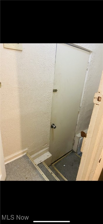 bathroom featuring a textured wall and walk in shower