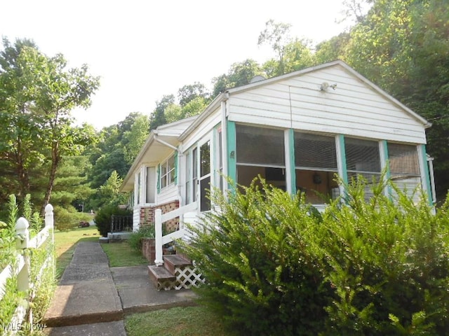 view of property exterior with a sunroom