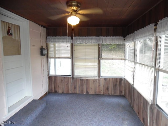 unfurnished sunroom featuring wooden ceiling and ceiling fan