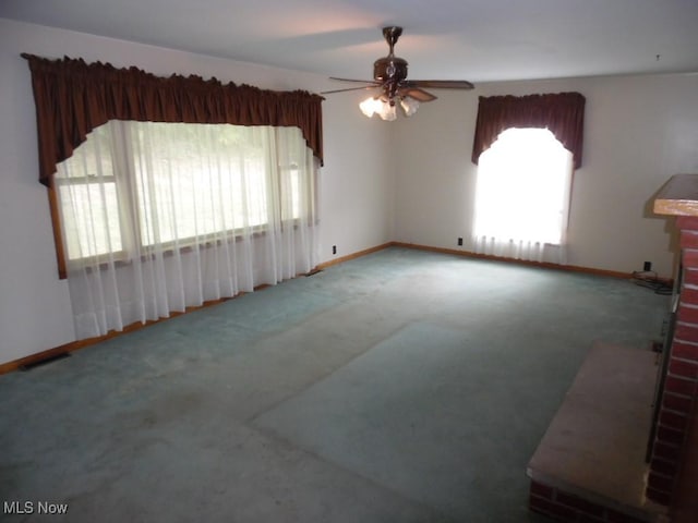 interior space featuring carpet, a wealth of natural light, and baseboards