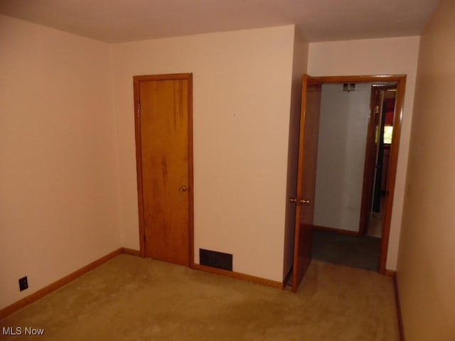 unfurnished bedroom featuring carpet floors, visible vents, and baseboards