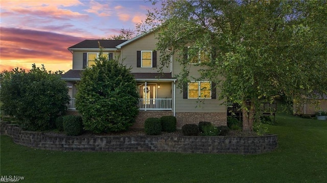 view of front of home featuring a porch and a yard