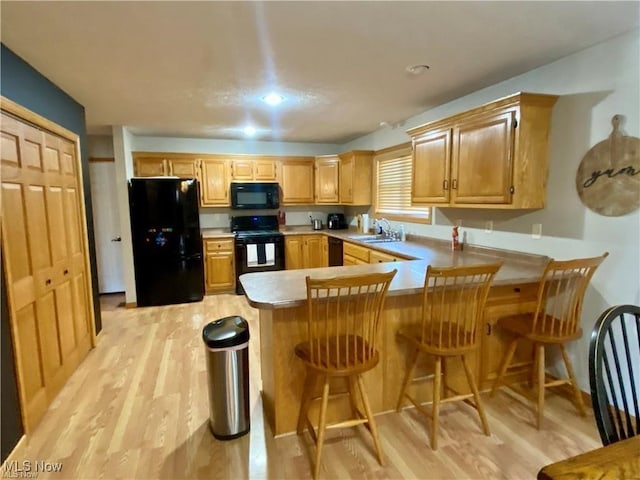 5 Grandview Dr, Mineral Wells, WV 26150 - kitchen with light wood-style floors, a peninsula, light countertops, black appliances, and a sink