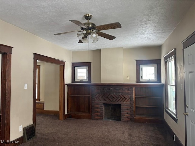 unfurnished living room featuring carpet, a textured ceiling, a fireplace, and visible vents