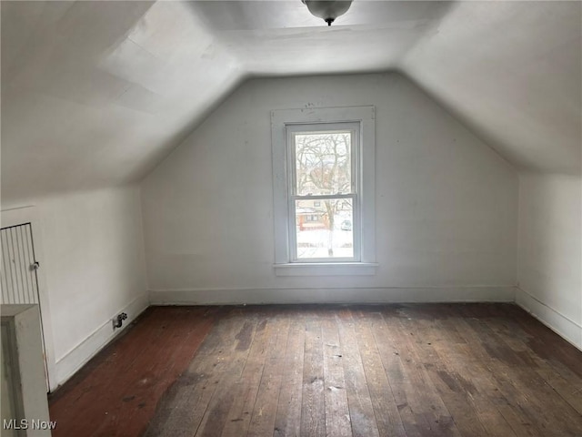 additional living space with lofted ceiling, hardwood / wood-style flooring, and baseboards