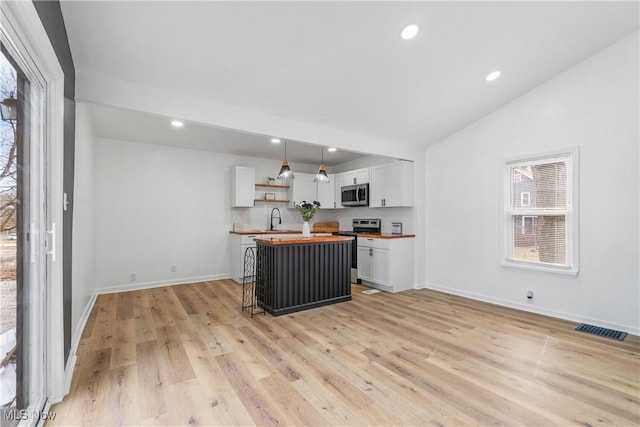 kitchen featuring butcher block counters, visible vents, appliances with stainless steel finishes, white cabinets, and a sink