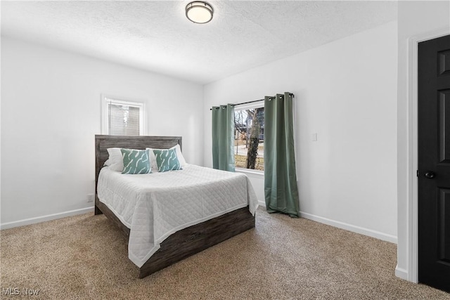 bedroom with a textured ceiling, baseboards, and carpet flooring