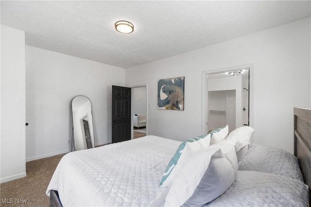 carpeted bedroom featuring baseboards and a textured ceiling