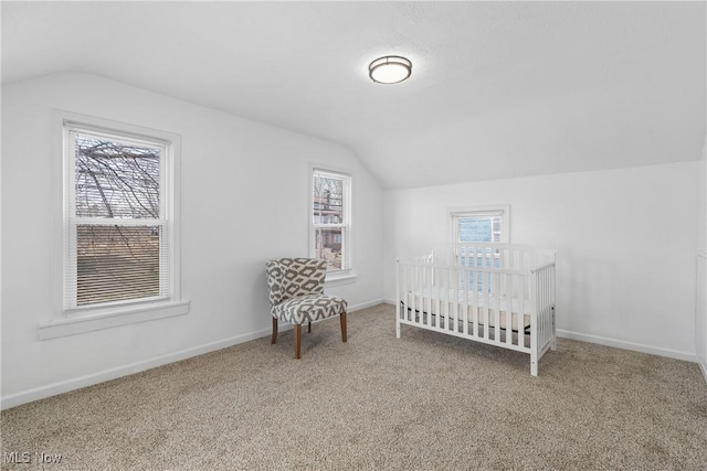 carpeted bedroom featuring lofted ceiling and baseboards