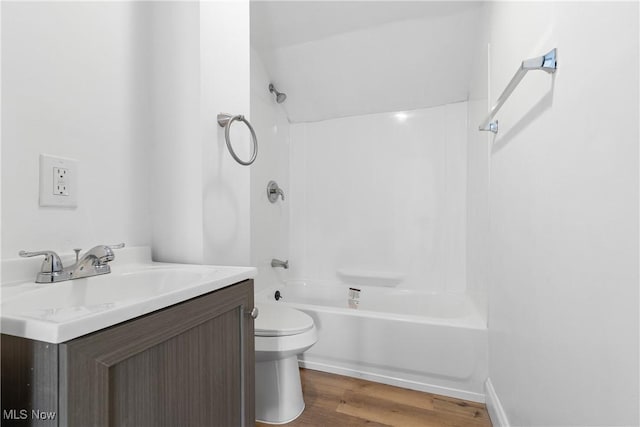 bathroom featuring  shower combination, vanity, wood finished floors, and toilet