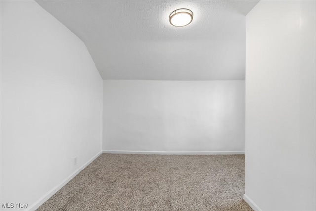 bonus room with carpet floors, vaulted ceiling, a textured ceiling, and baseboards