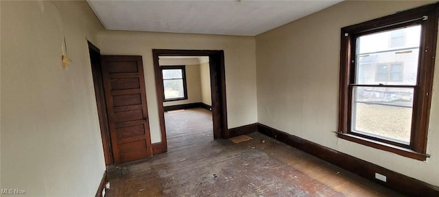 unfurnished room with baseboards