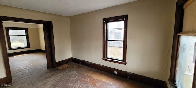 empty room with a wealth of natural light and baseboards