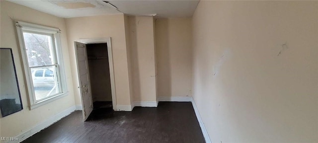 unfurnished bedroom with dark wood-type flooring and baseboards