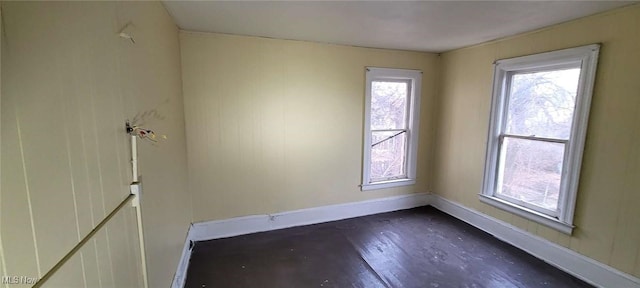 unfurnished room featuring dark wood-style floors and baseboards