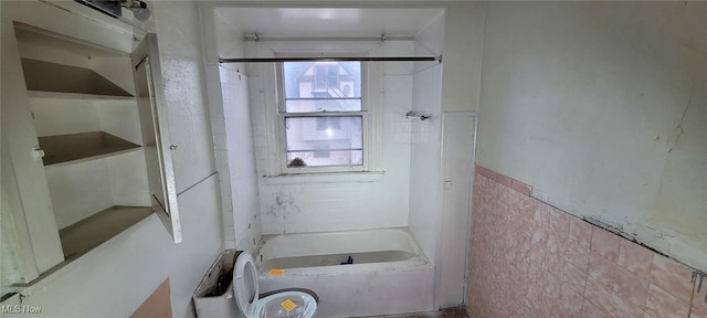 full bath featuring shower / washtub combination and tile walls