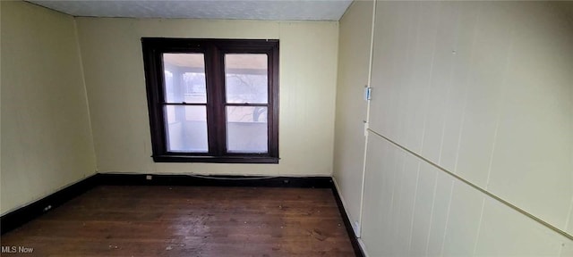 empty room featuring baseboards and wood finished floors