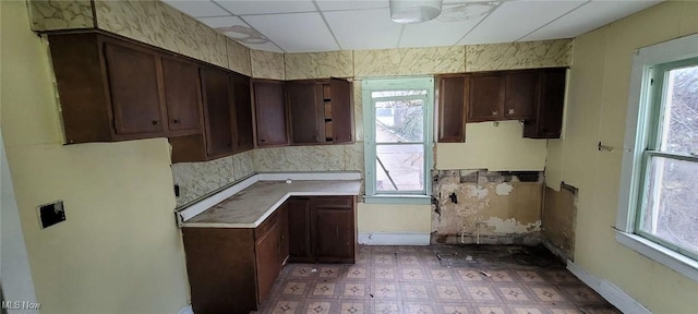 kitchen with baseboards, light countertops, and tile patterned floors