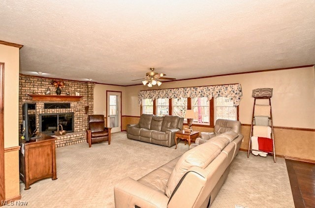 10400 Stoneacre St NW, Canal Fulton, OH 44614 - living area with a textured ceiling, a ceiling fan, a brick fireplace, ornamental molding, and light carpet