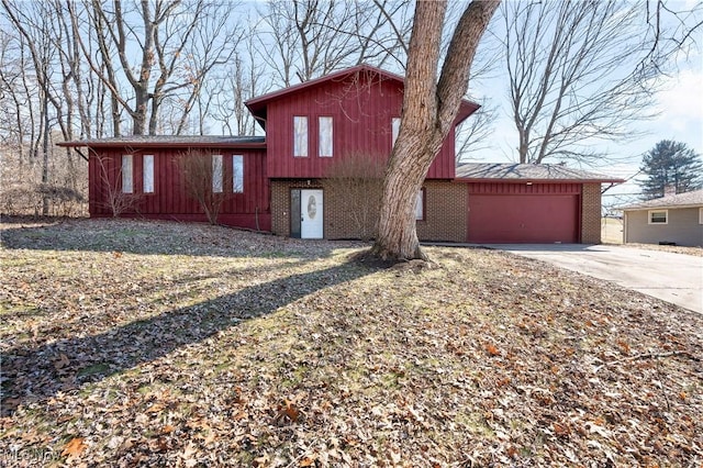 view of front of house featuring a garage, concrete driveway, and brick siding