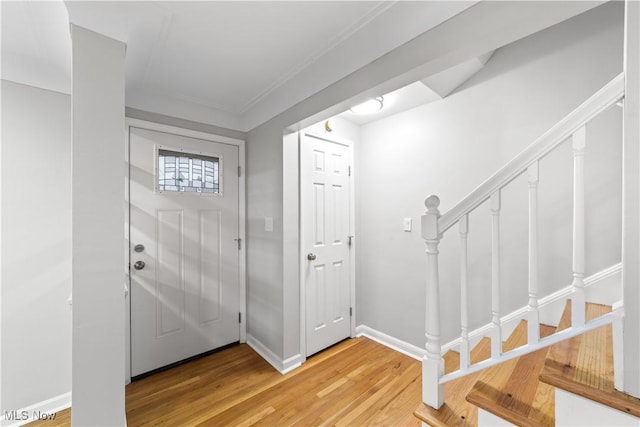 entrance foyer with stairway, baseboards, and wood finished floors