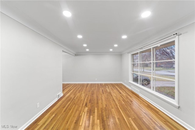 empty room with light wood-style floors, baseboards, visible vents, and recessed lighting