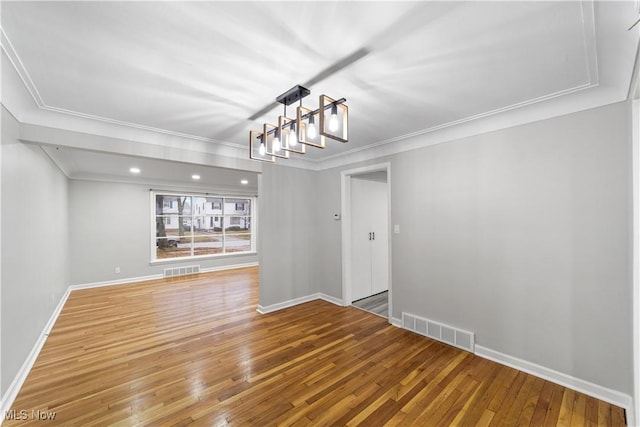 unfurnished dining area with baseboards, hardwood / wood-style floors, visible vents, and crown molding