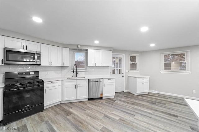 kitchen featuring stainless steel appliances, tasteful backsplash, a sink, and light countertops