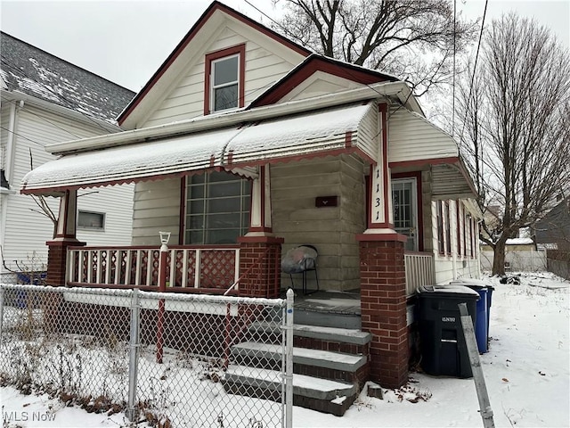 view of front of property featuring fence and a porch