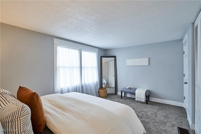 carpeted bedroom featuring baseboards, visible vents, and a textured ceiling